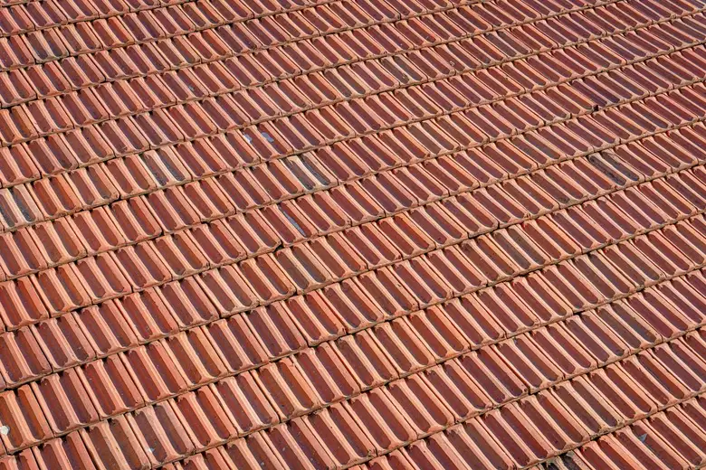 Aerial view of a textured clay tile roof showing the repeating tile pattern