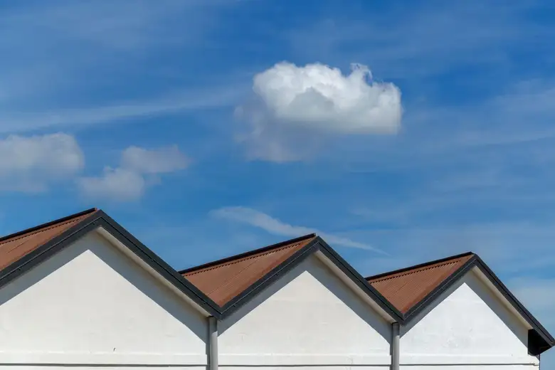 Sharp gable roofs of modern houses under a vibrant blue sky